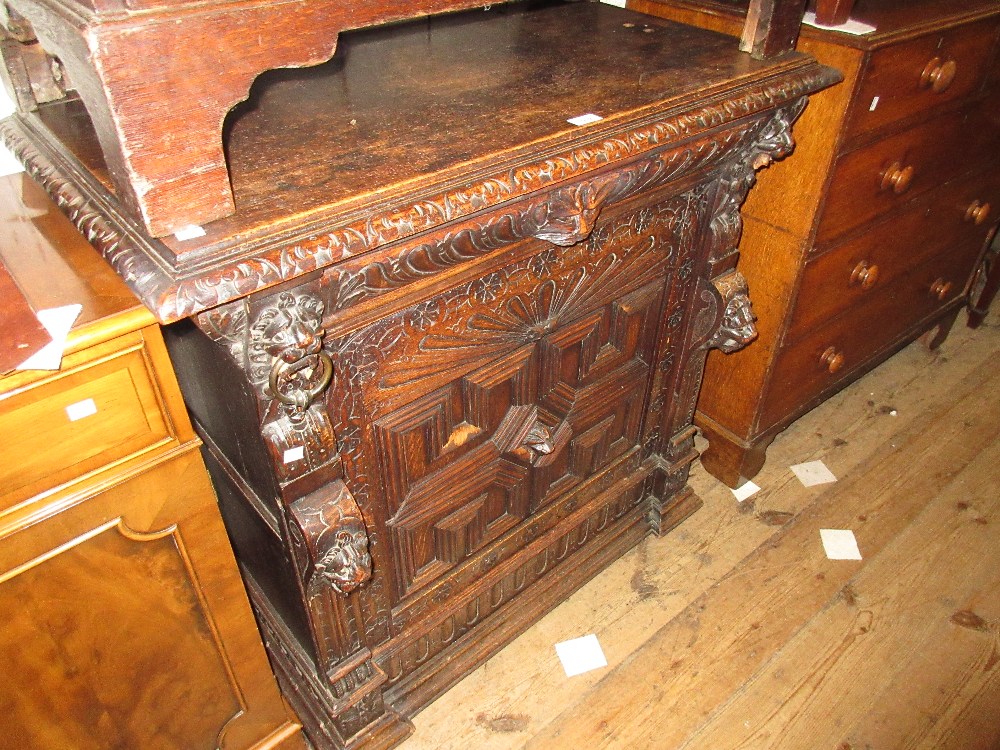 19th Century Continental carved oak side cabinet having a carved rim above maskhead drawer and