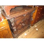 19th Century Continental carved oak side cabinet having a carved rim above maskhead drawer and
