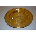 Antique circular brass alms dish, repousse decorated with a lion rampant