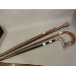 Two silver mounted walking sticks, another with white metal mount and a swagger stick