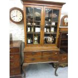 Walnut cabinet on stand, the moulded cornice above a pair of bar glazed doors enclosing shelves, the