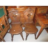 Pair of 19th Century Continental oak hall chairs with carved and pierced panel backs