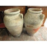 Pair of large weathered terracotta two handled baluster form garden urns with incised decoration,