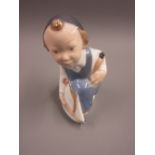 Small Royal Copenhagen porcelain figure of a boy with a model boat