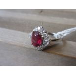 18ct White gold ruby and diamond set ring with a central oval treated ruby and tapered baguette