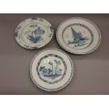 Large Delft ware plate painted with trees and buildings in Chinese style together with two others