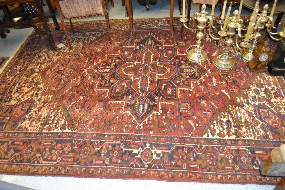 Heriz carpet having medallion and all-over floral design with borders on a wine ground, 10ft x 8ft