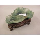 20th Century green stone carved dish in the form of lilies on a shaped hardwood stand with pierced