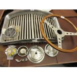 Wolsey motor car grill, a 1960's wooden and alloy steering wheel, Ford hub cap, Austin hub cap and