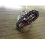 White gold dress ring set central oblong ruby flanked on each side by three small diamonds and the