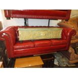 Pair of 20th Century red buttoned leather upholstered three seat chesterfield sofas raised on low