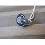 Large platinum target style ring set central diamond and calibre cut sapphires, the diamond
