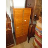 Mid 20th Century narrow chest of eleven drawers above a small cupboard
