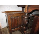 Small reproduction oak coffer with hinged lid above a linen fold front