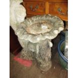 Small weathered cast concrete garden bird bath with figural base