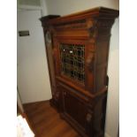 19th Century oak side cabinet, the moulded and carved cornice above a single leaded coloured glass
