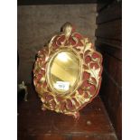 Gilt metal rococo style dressing table mirror on velvet backing, with easel