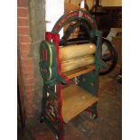 R. Nelson & Co., London, green and red painted mangle with gilt highlights, having original pine
