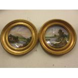 Pair of circular gilt framed Coalport plates decorated with landscapes
