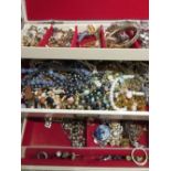 White jewellery box containing a large quantity of various costume jewellery
