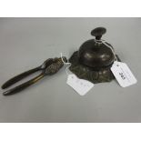 Patinated brass counter bell, together with a pair of patinated metal nut crackers with lion's