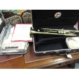 Cased Blessing trumpet together with a quantity of sheet music and a music stand