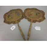 Pair of early 19th Century floral painted on card face screens with turned and gilded handles