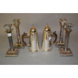 Set of four Goldsmiths Co. silver plated Corinthian column candlesticks on square stepped bases,