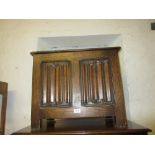 Small reproduction oak coffer with hinged lid above a linen fold front