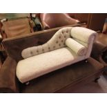 Reproduction miniature upholstered chaise longue raised on turned supports