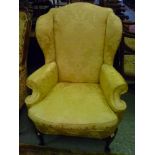 Early 20th Century gold damask upholstered wing armchair in 18th Century style on carved cabriole