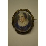 Portrait miniature of a lady wearing a lace bonnet and ruff collar with blue dress and gilt metal