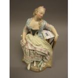 19th Century German porcelain figure of a seated sleeping girl, signed with blue cross mark to