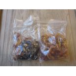 Two bags containing a quantity of amber coloured bead necklaces and another black bead necklace