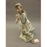 Lladro porcelain figure of a girl beside a stone bench, 11ins tall