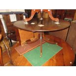 Reproduction mahogany circular pedestal dining table with a turned column support and reeded