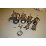 Four Eastern brass jugs, two oil burners and a pair of scales