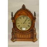 Victorian oak Gothic style bracket clock, having a circular silvered dial with Roman numerals,