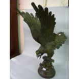 20th Century bronze figure of a bird of prey with wings outstretched on a branch, 29ins high Good