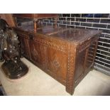 17th Century oak coffer, the plank top above carved three panel front raised on stile feet