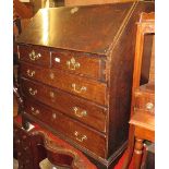 Early 19th Century oak bureau, the fall front enclosing a fitted interior over two short and three