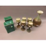 Iden pottery carafe with five matching goblets and a pair of pottery plinths