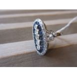 Platinum ring set five vertical graduated diamonds surrounded by calibre cut sapphires