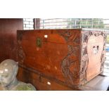 Oriental carved camphor wood trunk decorated in deep relief with stylised flowers, the hinged lid