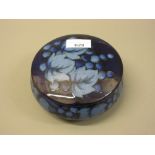Moorcroft circular pottery powder bowl with cover decorated with grapevines on a dark blue ground
