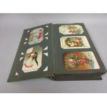 Green Art Deco postcard album containing over two hundred post cards - many humorous
