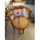 Pair of 20th Century cherry wood tub shaped office chairs with pierced backs above cane seats on