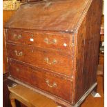 Early 19th Century oak bureau with a fall front above three graduated drawers, raised on bracket