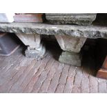 Small re-constituted stone garden bench with square baluster supports