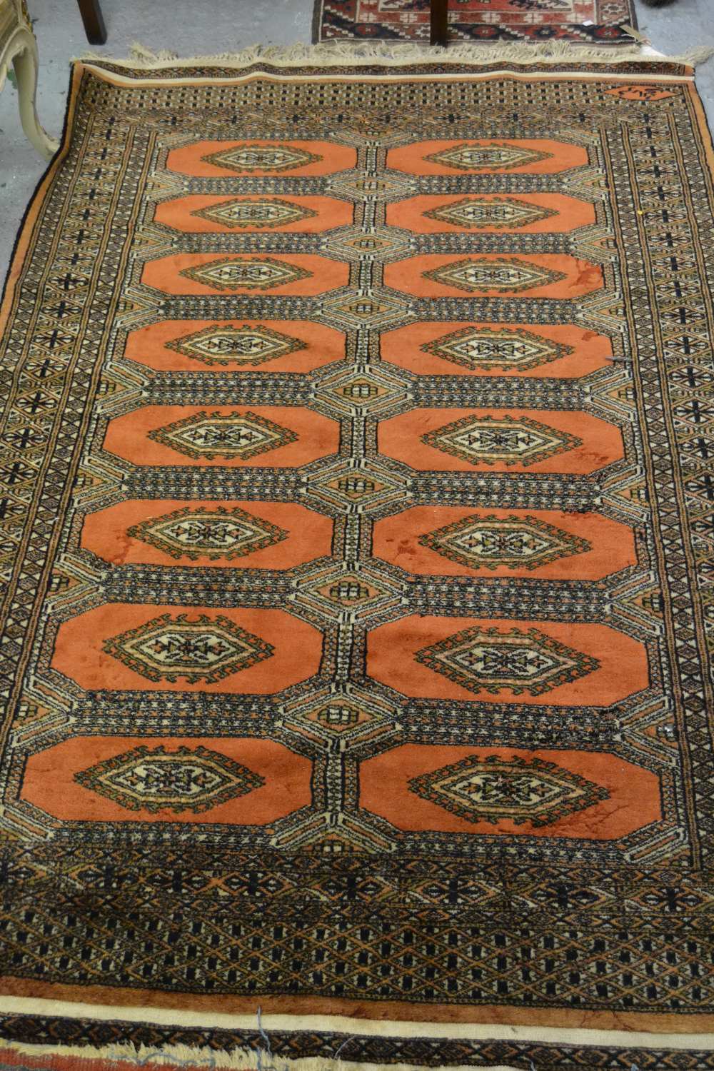 Pakistan rug of Turkoman design with two rows of eight gols on rust ground